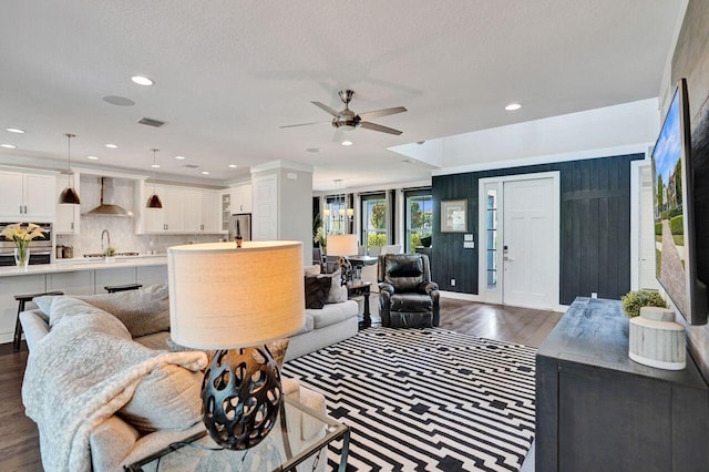 living area featuring visible vents, ceiling fan, recessed lighting, dark wood-style floors, and a textured ceiling