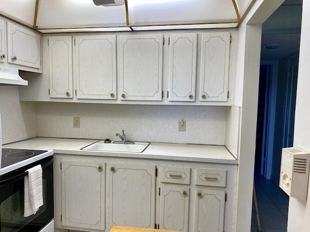 kitchen featuring a sink, range with electric stovetop, ventilation hood, and light countertops