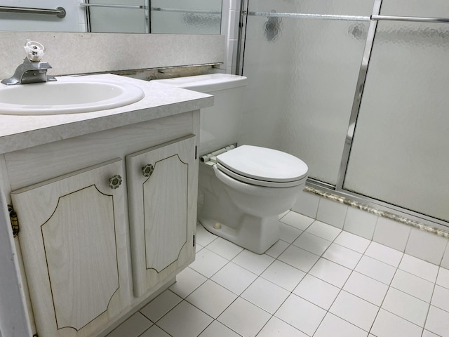 bathroom with tile patterned flooring, toilet, a stall shower, and vanity