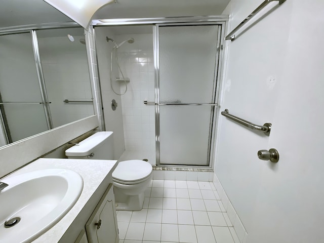 bathroom featuring vanity, toilet, a stall shower, and tile patterned flooring