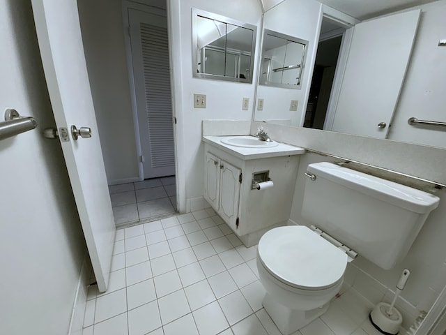 bathroom with tile patterned floors, baseboards, toilet, and vanity