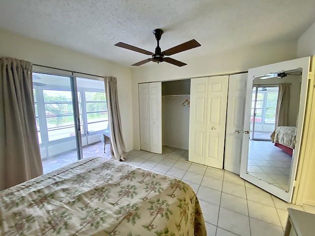 unfurnished bedroom with a ceiling fan, access to outside, a textured ceiling, a closet, and light tile patterned floors