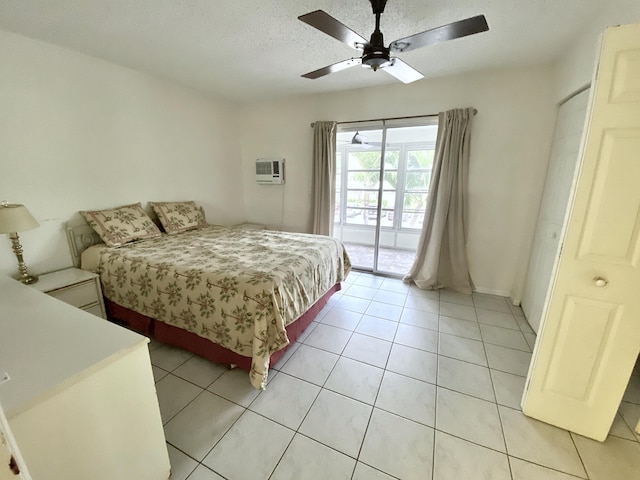 bedroom featuring access to outside, light tile patterned floors, a ceiling fan, and a textured ceiling