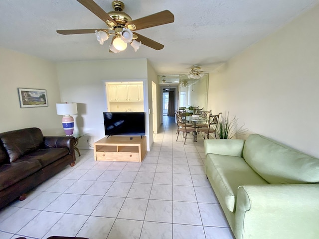 living room with light tile patterned floors, a textured ceiling, and a ceiling fan