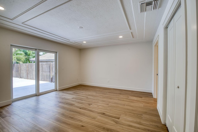 empty room with recessed lighting, visible vents, a textured ceiling, light wood-type flooring, and baseboards