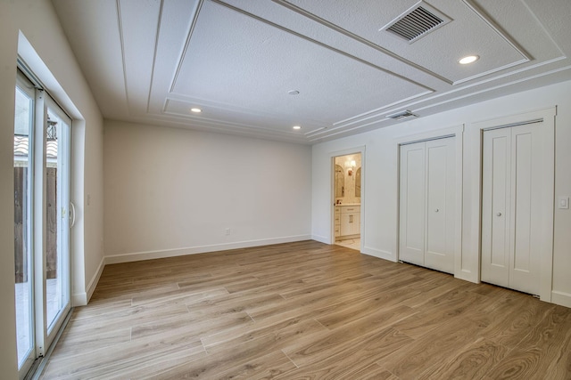 unfurnished bedroom featuring recessed lighting, visible vents, baseboards, light wood-type flooring, and two closets