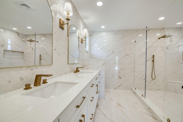 bathroom with stone wall, marble finish floor, and a sink