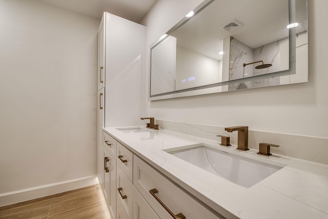 full bathroom featuring a walk in shower, visible vents, a sink, and wood finished floors