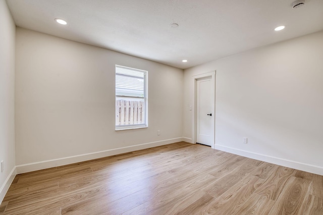 empty room with baseboards, recessed lighting, and light wood-style floors