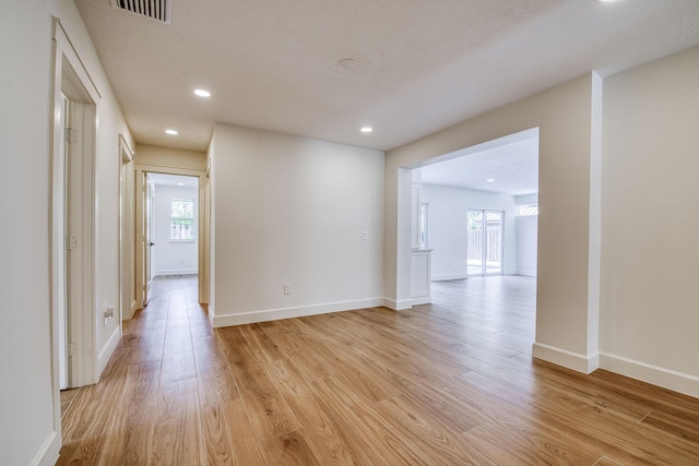 hall featuring baseboards, recessed lighting, visible vents, and light wood-style floors