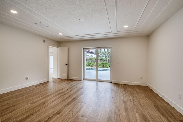 spare room featuring recessed lighting, a textured ceiling, baseboards, and wood finished floors