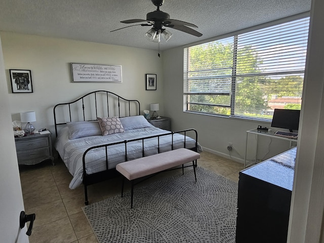 bedroom featuring light tile patterned floors, baseboards, a textured ceiling, and a ceiling fan