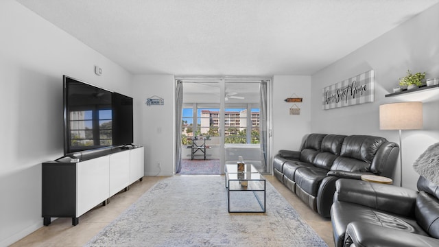 living area featuring light tile patterned floors, baseboards, and a ceiling fan