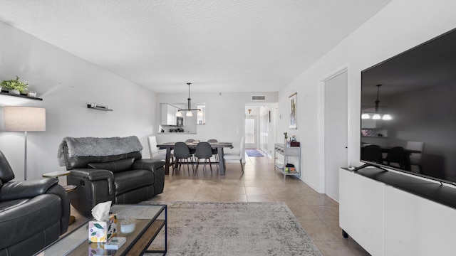 tiled living area featuring visible vents and a textured ceiling