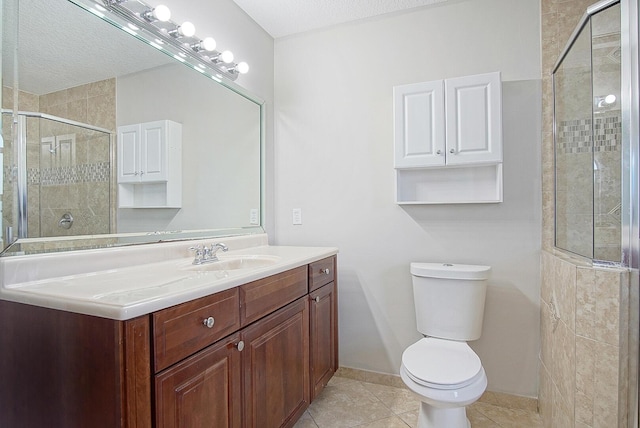 bathroom featuring tile patterned flooring, toilet, vanity, baseboards, and a shower stall