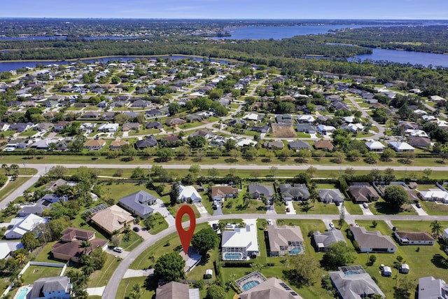 drone / aerial view with a residential view, a water view, and a forest view