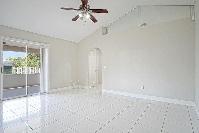 spare room featuring a ceiling fan, arched walkways, light tile patterned flooring, and baseboards