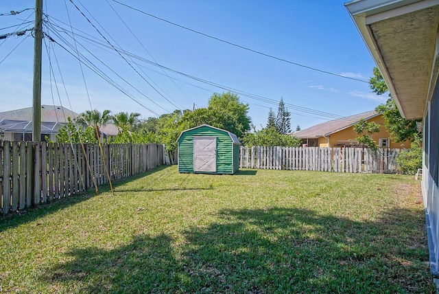 view of yard featuring a shed, an outdoor structure, and a fenced backyard