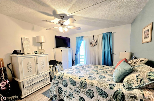 bedroom featuring light wood-type flooring, a textured ceiling, and ceiling fan