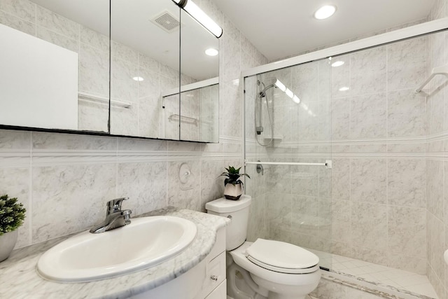 full bath featuring tile walls, visible vents, toilet, a shower stall, and vanity