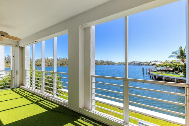 unfurnished sunroom featuring a water view and ceiling fan