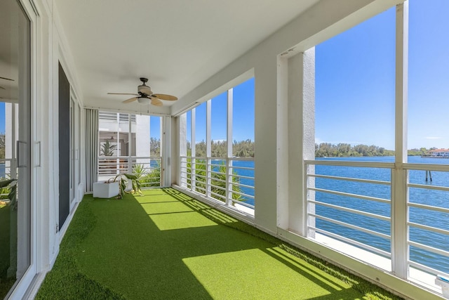 unfurnished sunroom featuring a water view and a ceiling fan