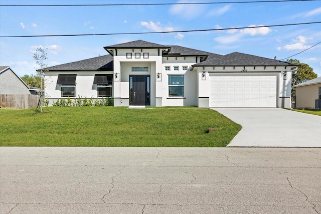 prairie-style home with an attached garage, stucco siding, concrete driveway, and a front yard