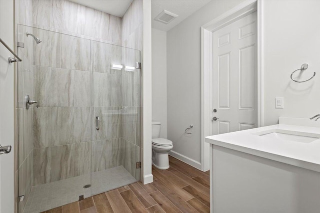 full bathroom with toilet, wood finish floors, visible vents, baseboards, and a shower stall