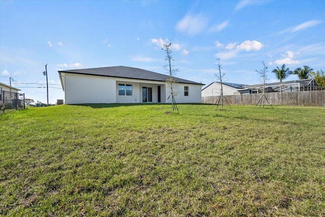 back of house featuring fence and a yard