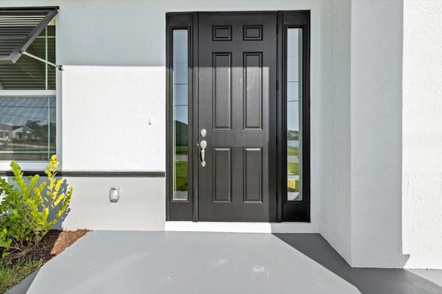 property entrance featuring stucco siding