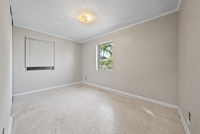 unfurnished room featuring concrete flooring, baseboards, and ornamental molding