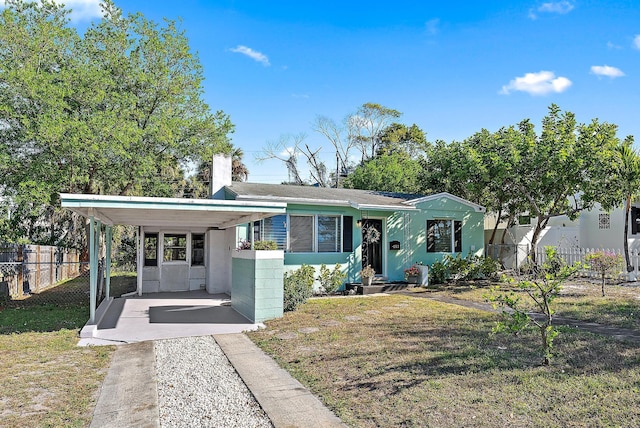 view of front of home with stucco siding, a chimney, a front yard, and fence