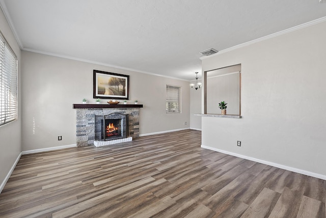 unfurnished living room featuring a fireplace, crown molding, baseboards, and wood finished floors