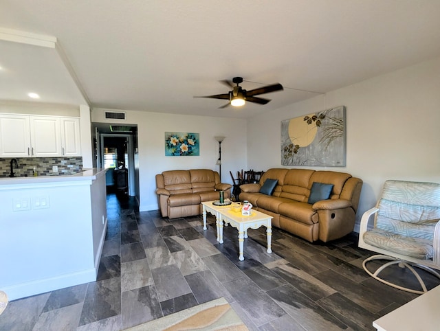 living room with visible vents, baseboards, and ceiling fan