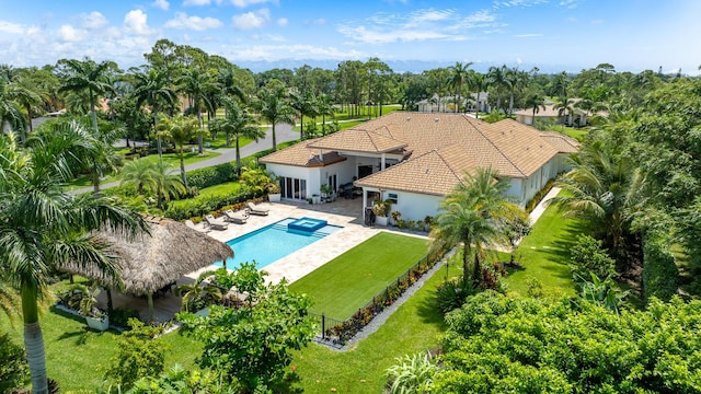 view of pool featuring a patio area, a pool with connected hot tub, a lawn, and a fenced backyard