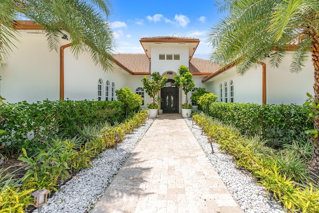 property entrance featuring stucco siding and a tiled roof