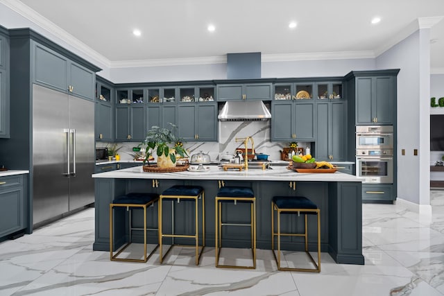 kitchen featuring under cabinet range hood, a breakfast bar area, light countertops, marble finish floor, and stainless steel appliances