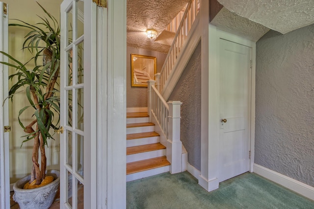 270 Cordova Rd, West Palm Beach, FL 33401 - stairway featuring a textured ceiling, a textured wall, baseboards, and carpet floors