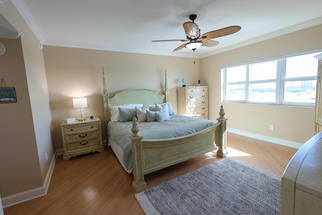 bedroom with baseboards, wood finished floors, and crown molding