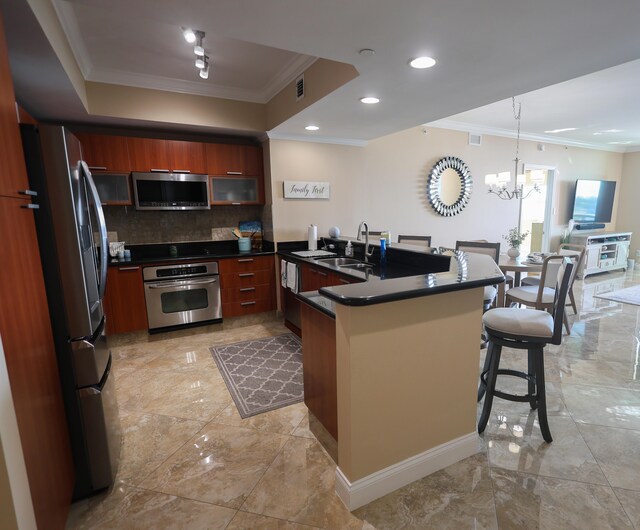 kitchen featuring a breakfast bar, a peninsula, a sink, appliances with stainless steel finishes, and dark countertops