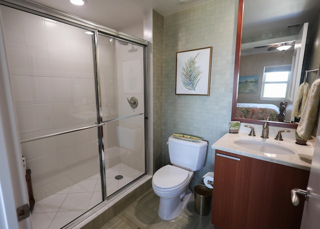 full bath featuring toilet, tile walls, a stall shower, and vanity