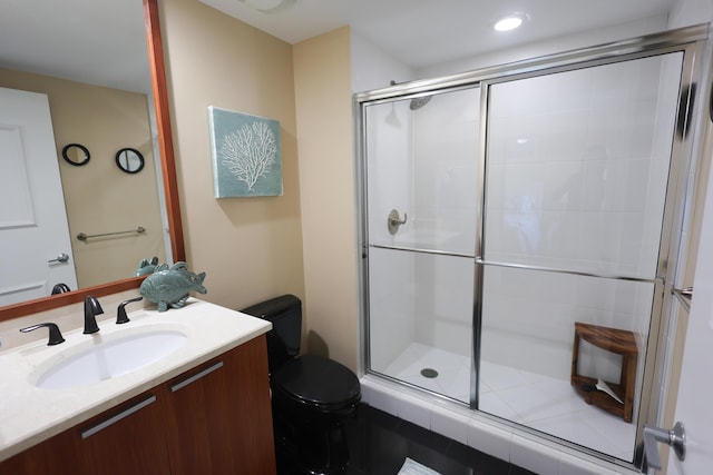 full bathroom featuring a shower stall, toilet, and vanity