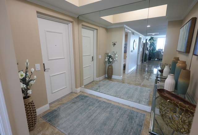 entrance foyer with baseboards and ornamental molding