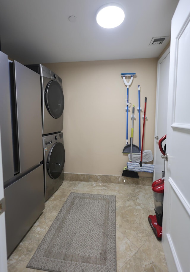 laundry area featuring laundry area, stacked washer / dryer, and visible vents