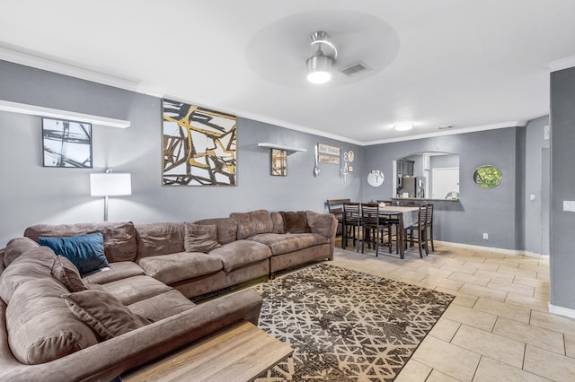 tiled living room with baseboards, visible vents, arched walkways, and ornamental molding