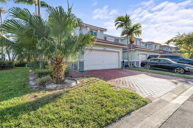 view of front of property with an attached garage, a tile roof, decorative driveway, stucco siding, and a front yard