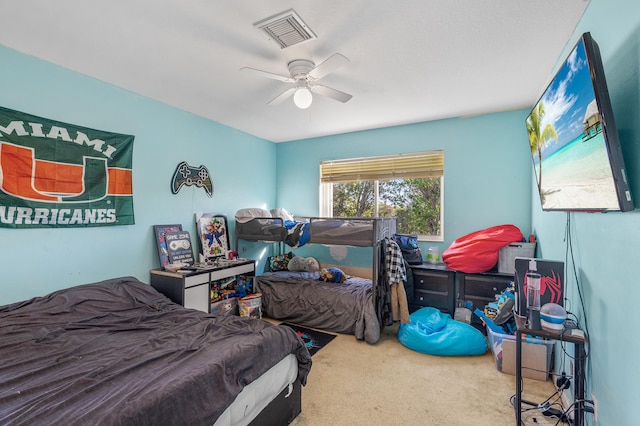 carpeted bedroom featuring visible vents and a ceiling fan