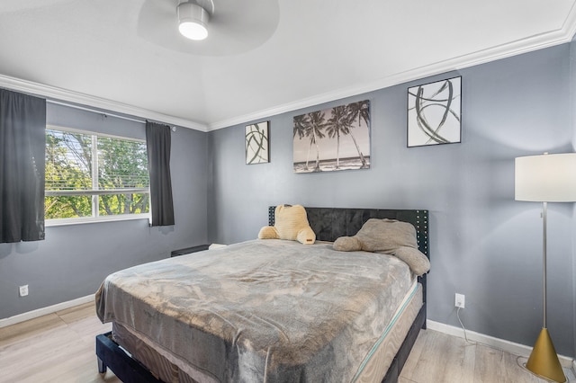 bedroom featuring a ceiling fan, baseboards, crown molding, and wood finished floors