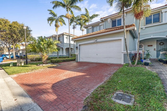 view of front of home with a tiled roof, decorative driveway, and stucco siding