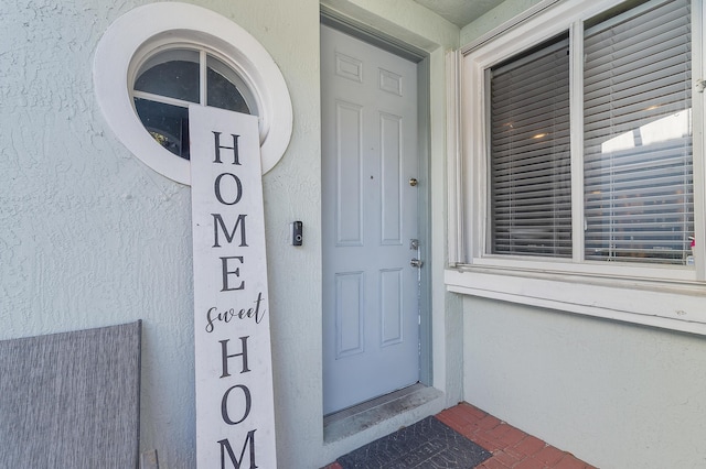 doorway to property featuring stucco siding